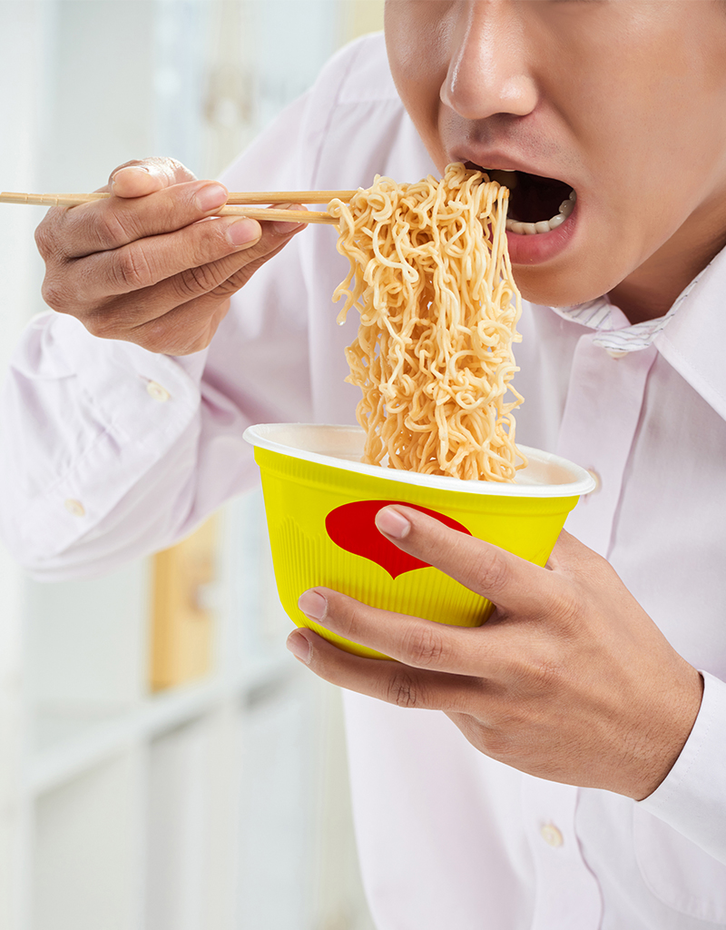 Man consuming instant noodles