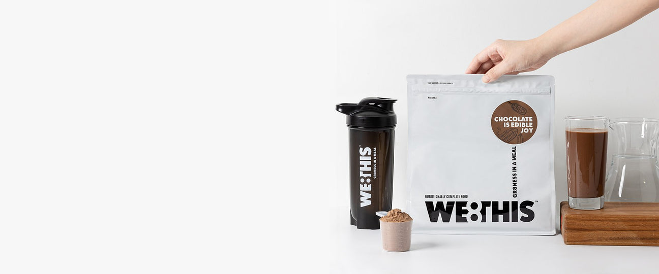 WE8THIS chocolate meal replacement drink in glass with shaker and scoop