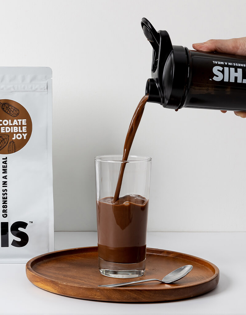 Person pouring WE8THIS meal replacement drink from shaker to glass