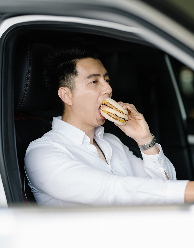 Man eating a burger while driving